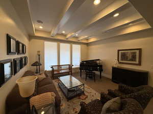 Carpeted living room with beam ceiling