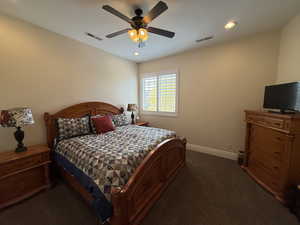 Bedroom with dark colored carpet and ceiling fan