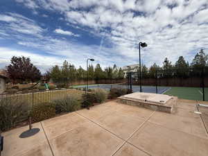 View of patio featuring basketball hoop, tennis court, and a playground