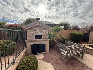 View of patio with an outdoor stone fireplace