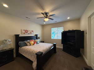 Bedroom with ceiling fan and dark carpet