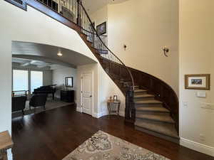 Stairs with hardwood / wood-style flooring and beam ceiling