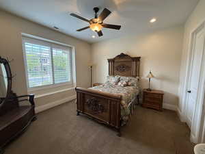 Bedroom with ceiling fan and dark carpet