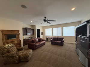 Carpeted living room with ceiling fan