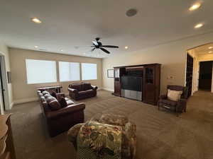 Carpeted living room featuring ceiling fan