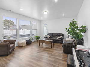 Living room featuring hardwood / wood-style floors and a textured ceiling