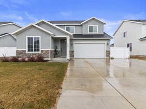 View of front of property with a garage and a front lawn