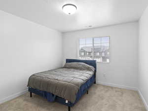 Carpeted bedroom with a textured ceiling