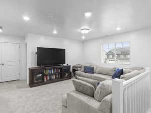 Carpeted living room with a textured ceiling