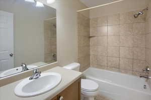 Full bathroom featuring vanity, toilet, and tiled shower / bath