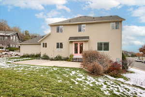 Rear view of property with a lawn, a patio area, and french doors