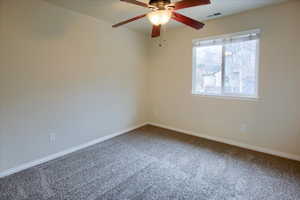 Spare room featuring carpet flooring and ceiling fan