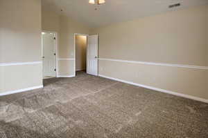 Carpeted spare room with high vaulted ceiling