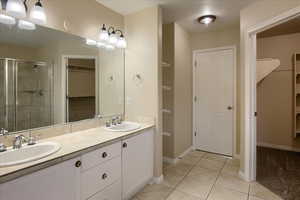 Bathroom with tile patterned flooring, vanity, and an enclosed shower