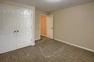 Unfurnished bedroom with a closet and carpet floors