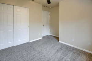 Unfurnished bedroom with carpet flooring, ceiling fan, and a closet