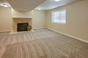 Unfurnished living room with carpet flooring and a fireplace