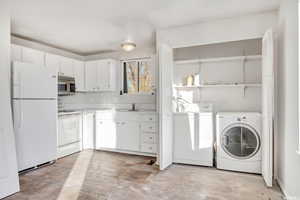 Washroom featuring separate washer and dryer and sink