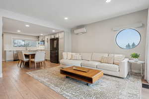 Living room featuring a wall unit AC and light wood-type flooring