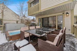 Snow covered deck with a covered hot tub