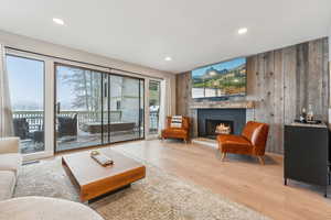 Living room featuring a fireplace, light hardwood / wood-style floors, and wood walls