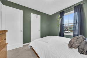 Carpeted bedroom featuring a textured ceiling