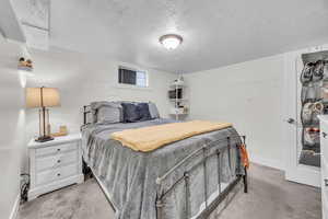 Bedroom with light carpet and a textured ceiling