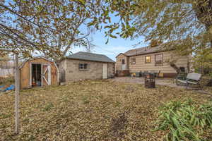 Back of property with a shed, a patio area, and central air condition unit