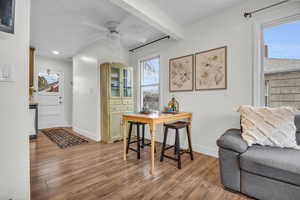 Dining space with hardwood / wood-style flooring, ceiling fan, a healthy amount of sunlight, and beam ceiling