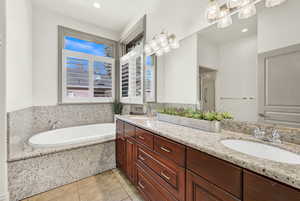 Main Bathroom with separate shower and tub, tile patterned flooring, and vanity