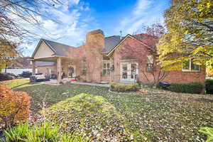 Rear view of house featuring outdoor lounge area, a patio area, and a lawn