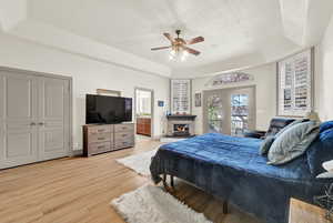 Main Bedroom featuring a tray ceiling, ceiling fan, light hardwood / wood-style floors, and access to outside