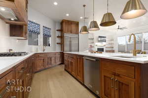 Kitchen with ceiling fan, sink, decorative light fixtures, appliances with stainless steel finishes, and light wood-type flooring