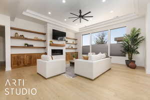 Living room featuring a raised ceiling, visible vents, light wood-style flooring, a large fireplace, and baseboards