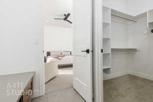 Walk in closet featuring ceiling fan and light colored carpet