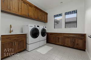 Laundry area with washer and dryer, cabinets, and sink