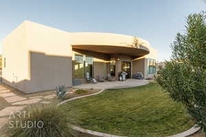 Rear view of property with a yard and a patio