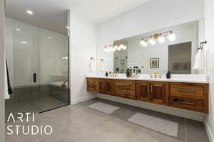 Bathroom with a sink, baseboards, tile patterned floors, double vanity, and a stall shower