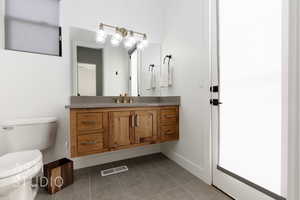 Bathroom with tile patterned floors, vanity, and toilet