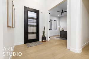 Foyer entrance with light wood-type flooring, baseboards, and a ceiling fan