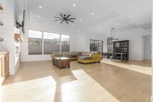 Living room with ceiling fan and light hardwood / wood-style floors