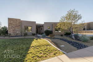 Pueblo revival-style home with a front lawn