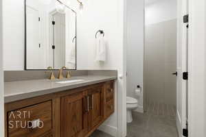 Bathroom with tile patterned flooring, vanity, and toilet