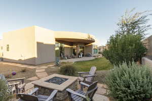 Back of property featuring a patio, a fire pit, and a lawn