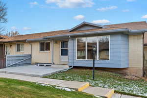 Rear view of property with a lawn and a patio area