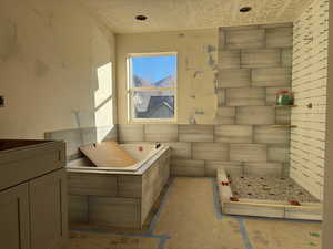 Bathroom featuring a bath and a textured ceiling