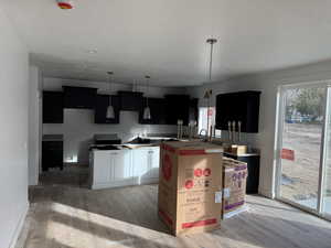 Kitchen with a textured ceiling, light hardwood / wood-style flooring, and a kitchen island