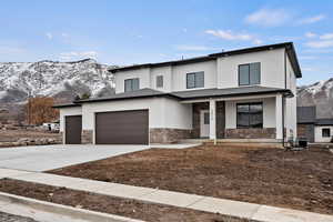 View of front facade featuring a garage, a mountain view, a porch, and central AC unit