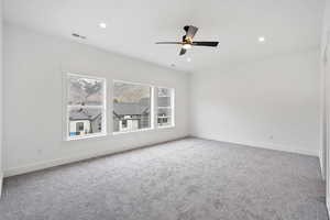 Empty room with ceiling fan and carpet flooring