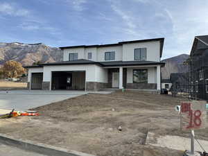 View of front of house with a mountain view, covered porch, and a garage